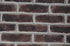 Close-up of a brick wall with dark red bricks