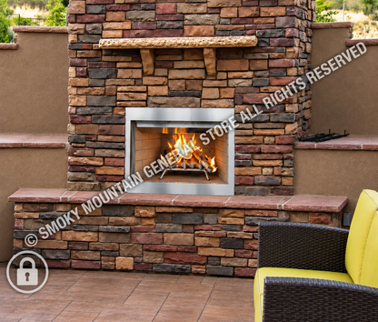 A built-in outdoor fireplace with a rectangular stainless steel firebox and visible flames, set into a stacked stone wall with a stone mantel and brick hearth. 
